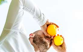 Frau im Blumenhemd vor einer Hecke